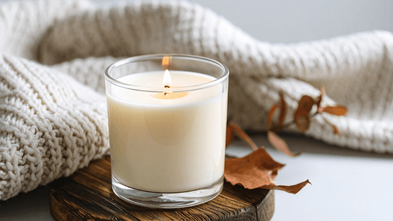 A fragranced candle showcasing the fall seasons as part of 10 morning habits to ease into fall.