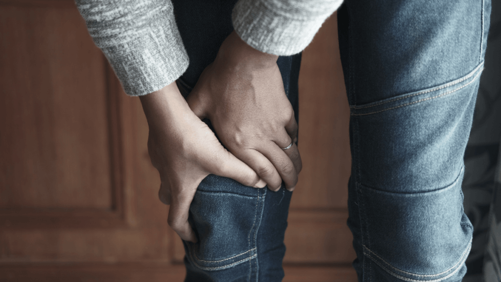 Person grabbing their knee to represent the common causes of knee pain after workouts
